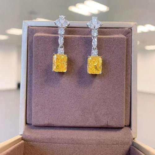 Yellow rectangular CZ drops displayed upright on mauve jewelry cushion