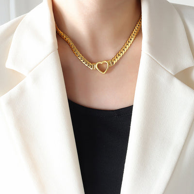 Woman in white blazer wearing gold Cuban link open heart choker necklace