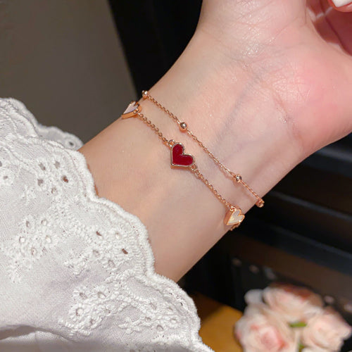 Wrist wearing rose gold double layer red and pearl heart bracelet