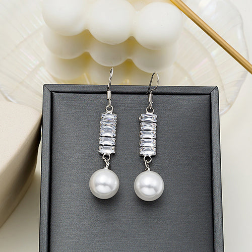 Silver tone baguette crystal bar pearl drop earrings on black display pad