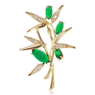 Gold bamboo branch brooch with green stones and rhinestone leaves front view