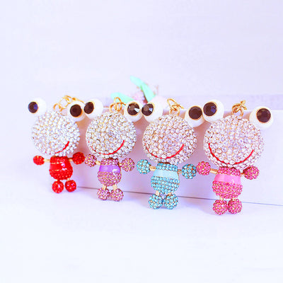 Four rhinestone frog ornaments in red, purple, blue, and pink are displayed together.