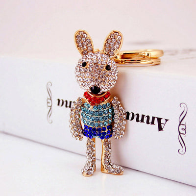 Angled front view of the stone-covered rabbit figure with the key ring behind it.