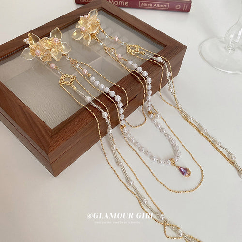 gold-tone floral hair clip with long pearl and chain drapes shown worn in a styled second view