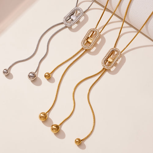Gold and steel oval zircon slider Y-necklaces with ball tips flat lay