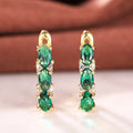 Green Oval Three-Stone Long Drop Earrings In Polished Gold Tone view 1