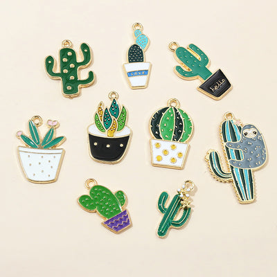 Front overview of colorful enamel cactus and potted plant pendant charms arranged on a light background