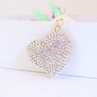Clear rhinestone heart charm hanging from a gold-tone metal loop.