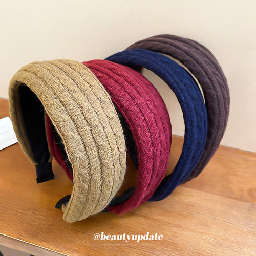 Four cable knit padded headbands in camel red navy and brown on wood table