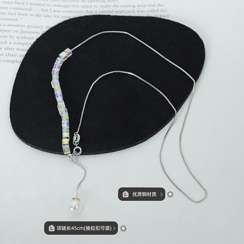 Full steel necklace laid on black tray showing length and material labels