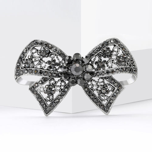 Angled product view of 枪黑蝴蝶结胸针 showing surface color and shine