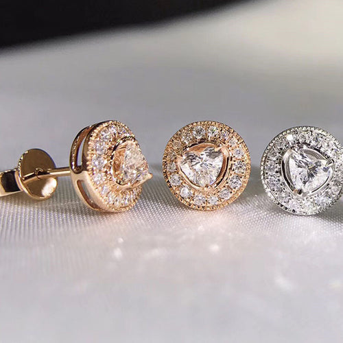 Styled view of round crystal halo stud earrings in three metal tones