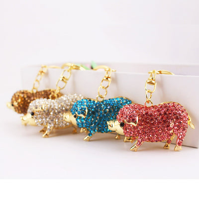 Four rhinestone pig keychains in brown, clear, blue, and pink colors.