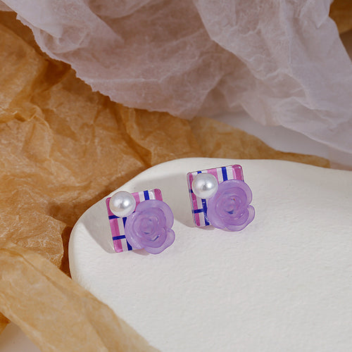 Purple rose plaid pearl stud earrings on white stone with crumpled paper