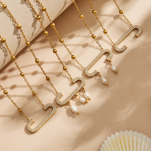 Close gold pave paperclip pendants with pearl drops on beige