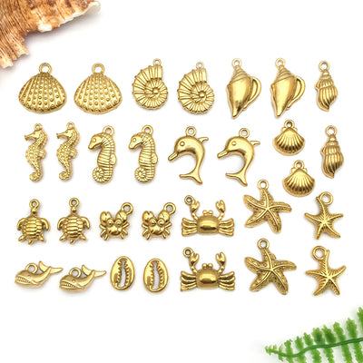 Gold-tone shell and starfish charms arranged on a light background