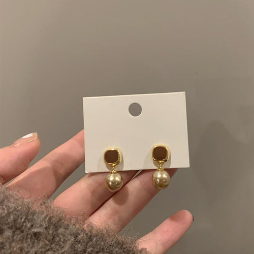 champagne pearl drop stud earrings displayed from a second angle