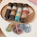 Tube Of One Hundred Thin Elastic Hair Ties In Black Or Pastel Colors view 4