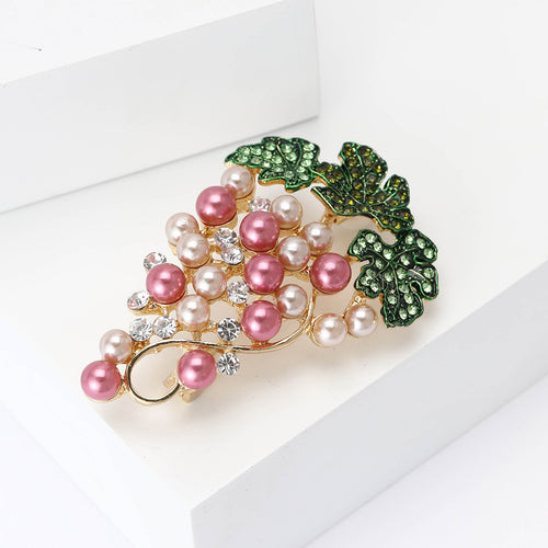 Grape cluster brooch angled on white display blocks