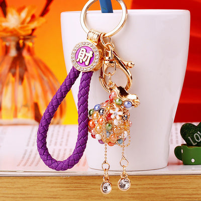 A front product view shows the beaded pouch keychain with its visible ornament and hanging hardware.