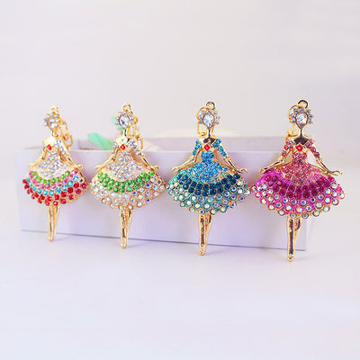 Four gold-tone ballerina charms displayed in multicolor, green, blue, and pink dresses.