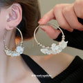 Gold Tone Hoop Earrings With White Floral and Pearl Like Accents view 1