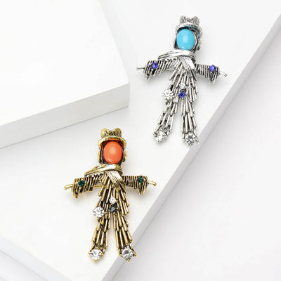 Gold and silver scarecrow brooches with cabochon faces