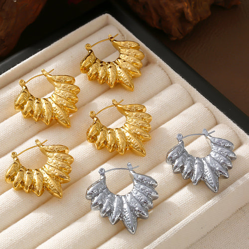 Gold and steel leaf cluster hoops arranged in cream jewelry tray