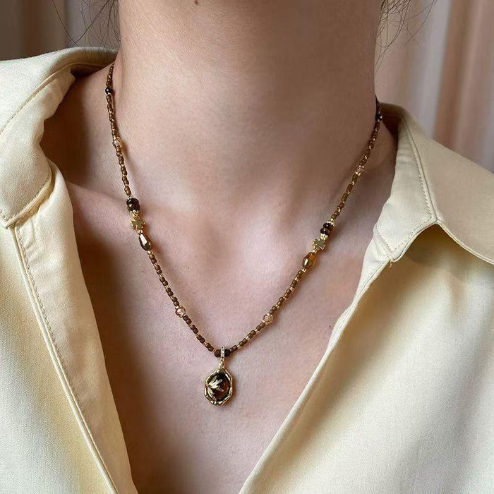 Brown And Gold Tone Beaded Necklace With Dark Round Pendant
