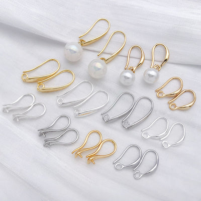 Gold-tone earring hook jewelry findings arranged on a light background