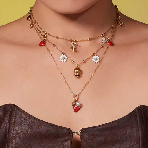 Neckline view of strawberry seahorse and daisy charm necklaces in main image 2.