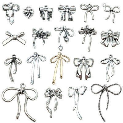 Metallic bow and butterfly charms arranged on a light background