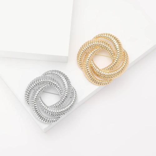 Product image 1 showing the textured interlocking loop brooch in silver or gold.