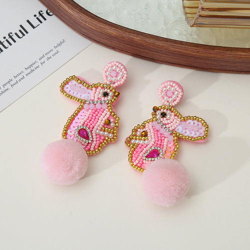 Pink beaded bunny drop earrings with a plush pom-pom tail