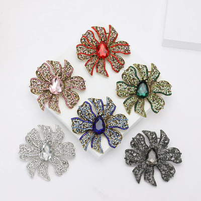 Grouped view of six oversized ribbon flower brooch colors arranged together.