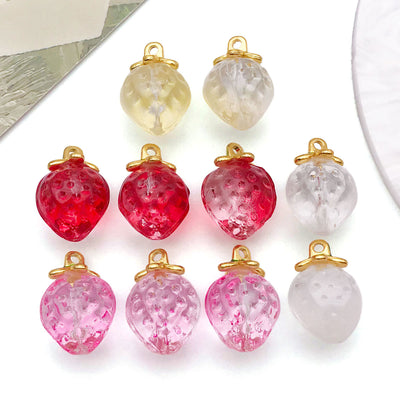 Clear strawberry charms arranged on a light background