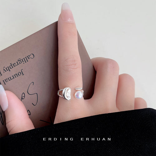 Silver-tone sculpted-leaf white-pearl open ring shown worn on a hand.