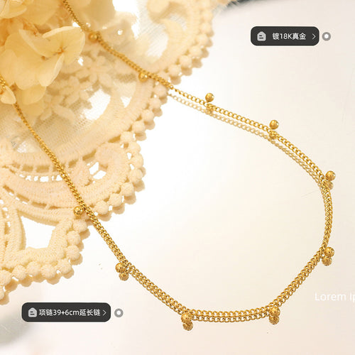 Close flat lay of gold ball-bead chain with plating and length labels