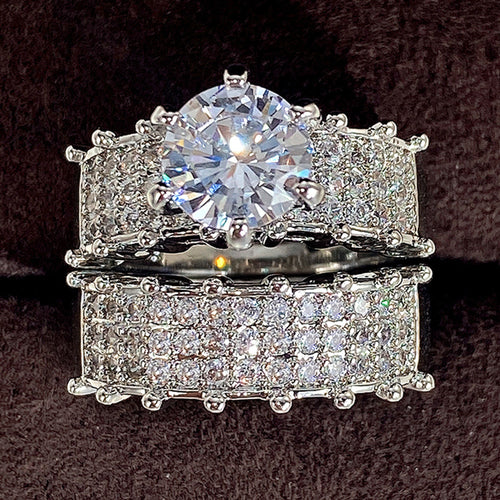 Second product view showing silver-tone round solitaire and extra-wide pave two-ring set