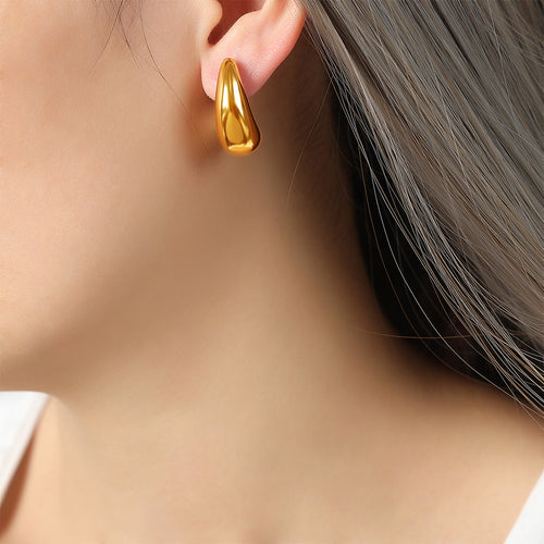 Gold thick crescent moon stud earring worn on ear profile