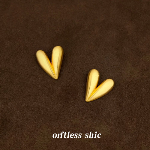 Gold matte heart studs on brown suede fabric