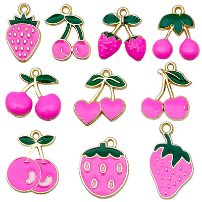Red strawberry and cherry charms arranged on a light background