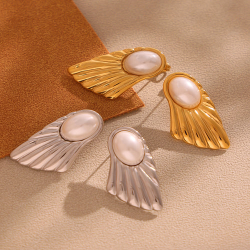 Gold and steel fan shell pearl studs on beige and brown surface