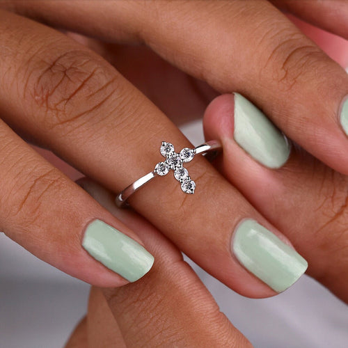 Silver cross stone ring worn with mint green nail polish