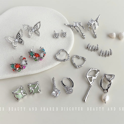 Assorted silver earring collection flat lay with butterflies stars and drips