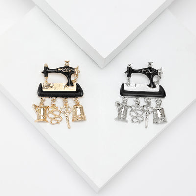 Front view of the enamel sewing machine brooch with dangling tools decorative clothing pin on a white background
