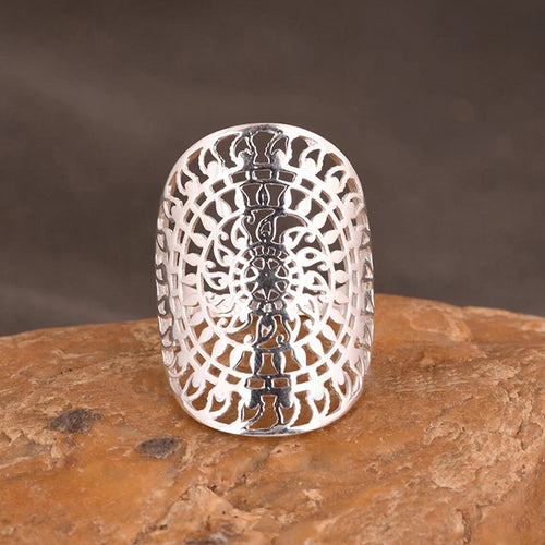 Silver openwork filigree flower ring standing on brown stone