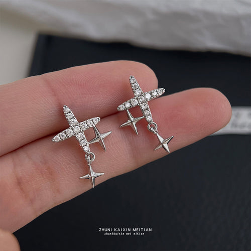Silver pave starburst double star studs held on fingers