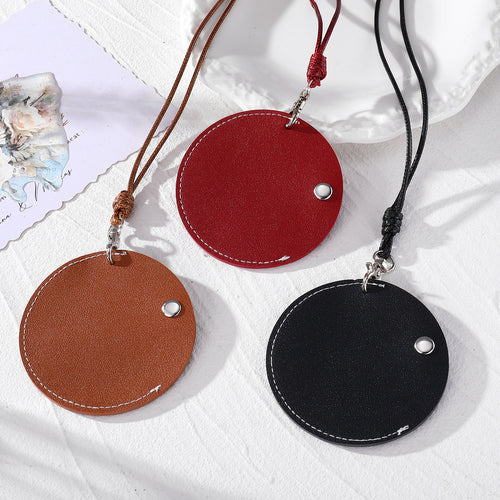 Three round leather snap pouch necklaces in brown wine red and black with matching cords