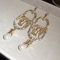 Ornate Crystal Drop Statement Earrings with Polished Metal Tone Details view 6